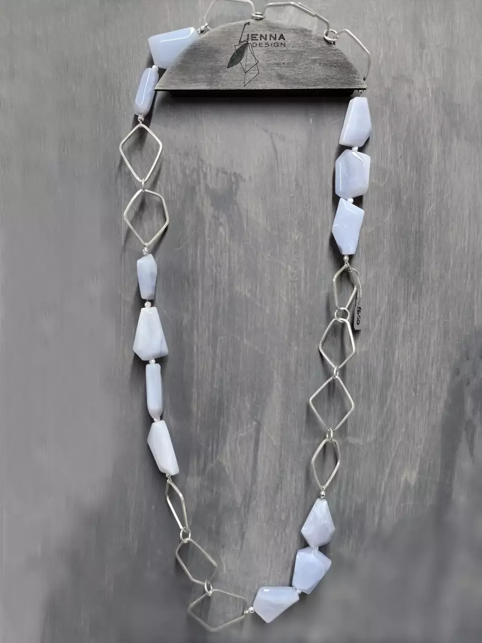 chalcedony necklace with pearls and hex shaped silver links on display board showing full length of necklace